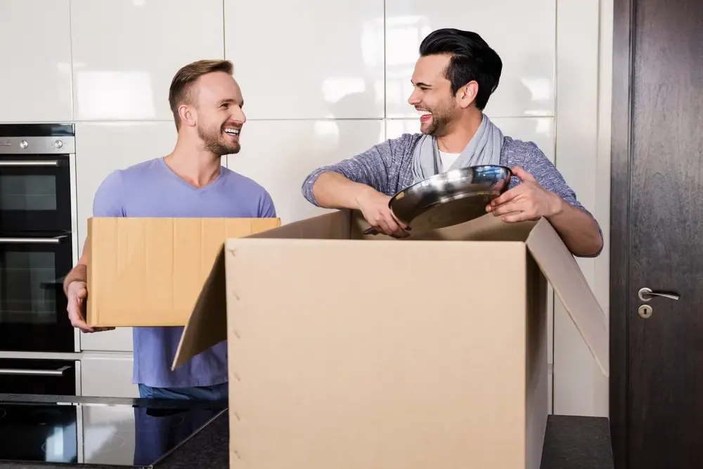First-time home buyers unpacking moving boxes in a new home after purchasing a property in Canada.