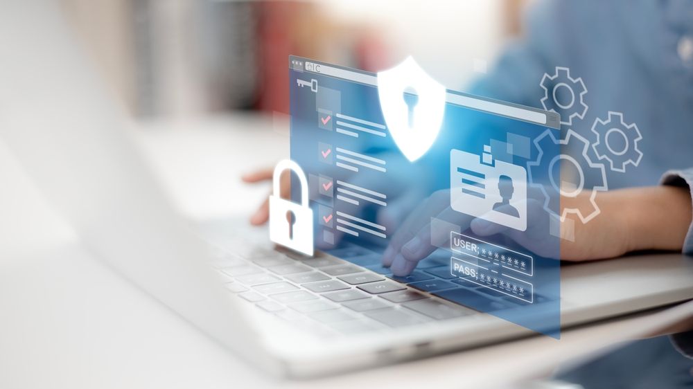 Secure tax filing in Canada: A user types on a laptop protected by cybersecurity overlays.